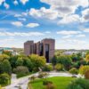 skyline view of UW-Green Bay campus with one central building, trees, and a green lawn